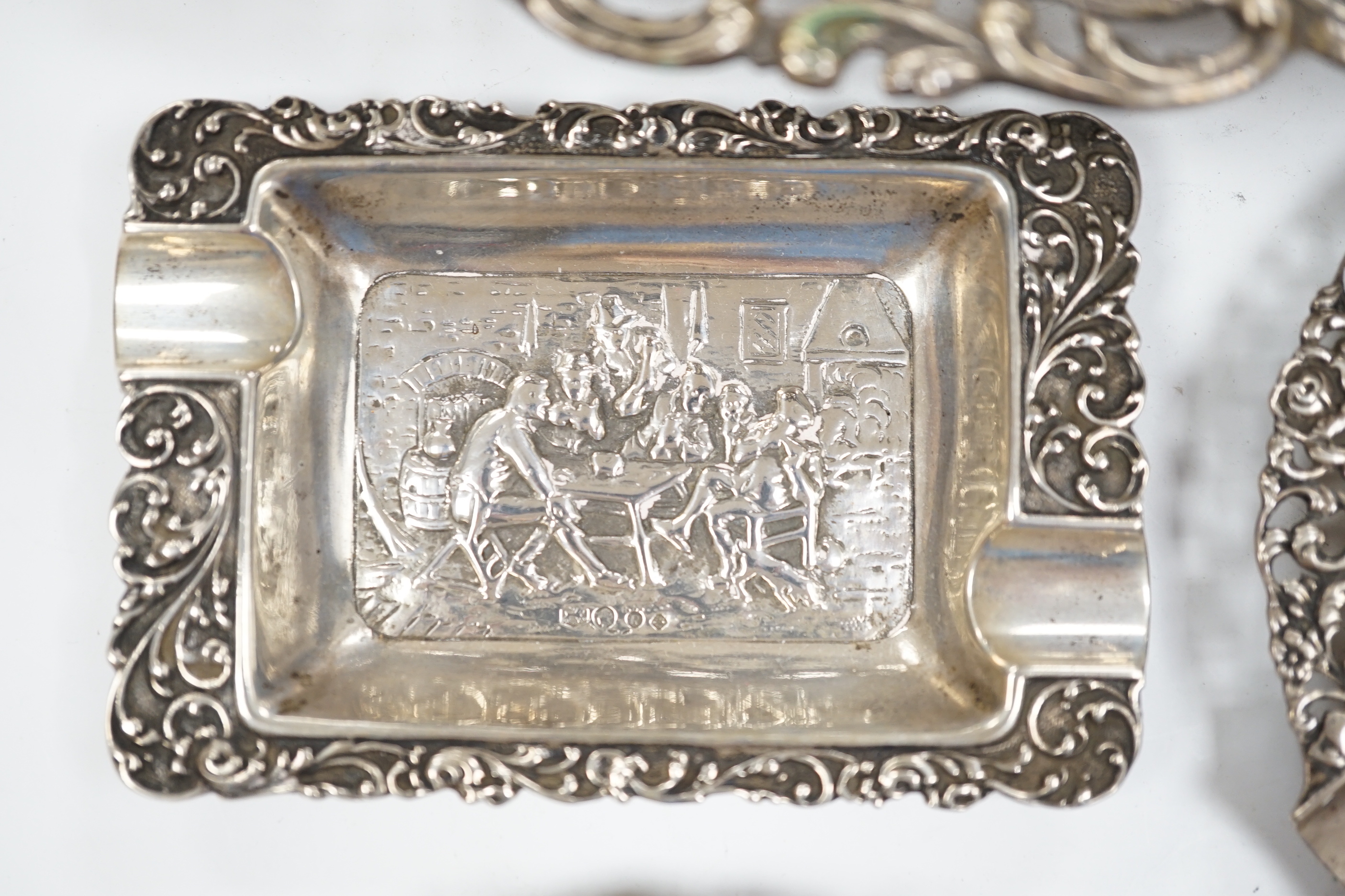 A German pierced 800 white metal oval dish, 28.4cm, three Dutch white metal ashtrays and an 835 white metal lighter.